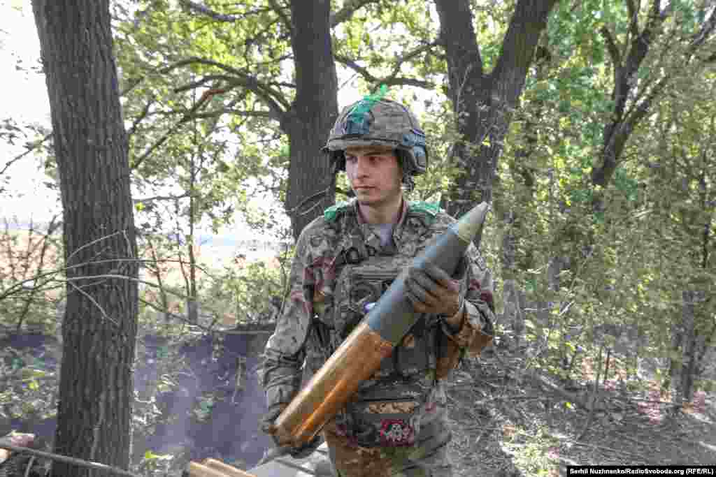 В Олександра вже готовий снаряд, він швидко його передає Дмитру, який за мить його заряджає