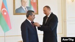 Prezident İ.Əliyev KİVDF-nin keçmiş rəhbəri V.Səfərliyə 3-cü dərəcəli "Vətənə xidmətə görə" ordenini təqdim edir. 2015